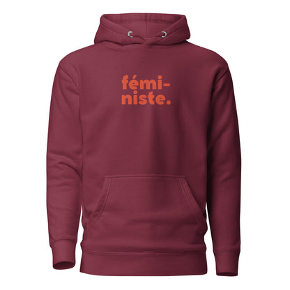 Maroon hoodie, front view, with red stacked 'fémi-niste.' lettering.