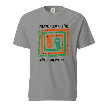 Grey T-shirt, front view, with orange and green abstract faces framed by 'All We Need Is Love' text.