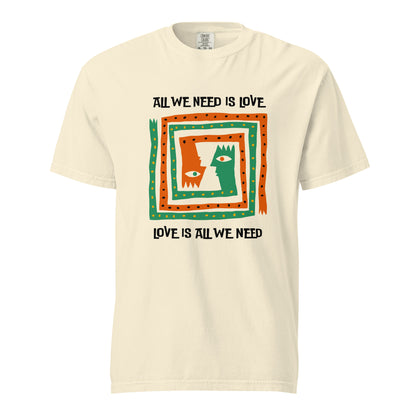 Ivory T-shirt, front view, with orange and green abstract faces framed by 'All We Need Is Love' text.