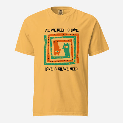 Mustard T-shirt, front view, with orange and green abstract faces framed by 'All We Need Is Love' text.