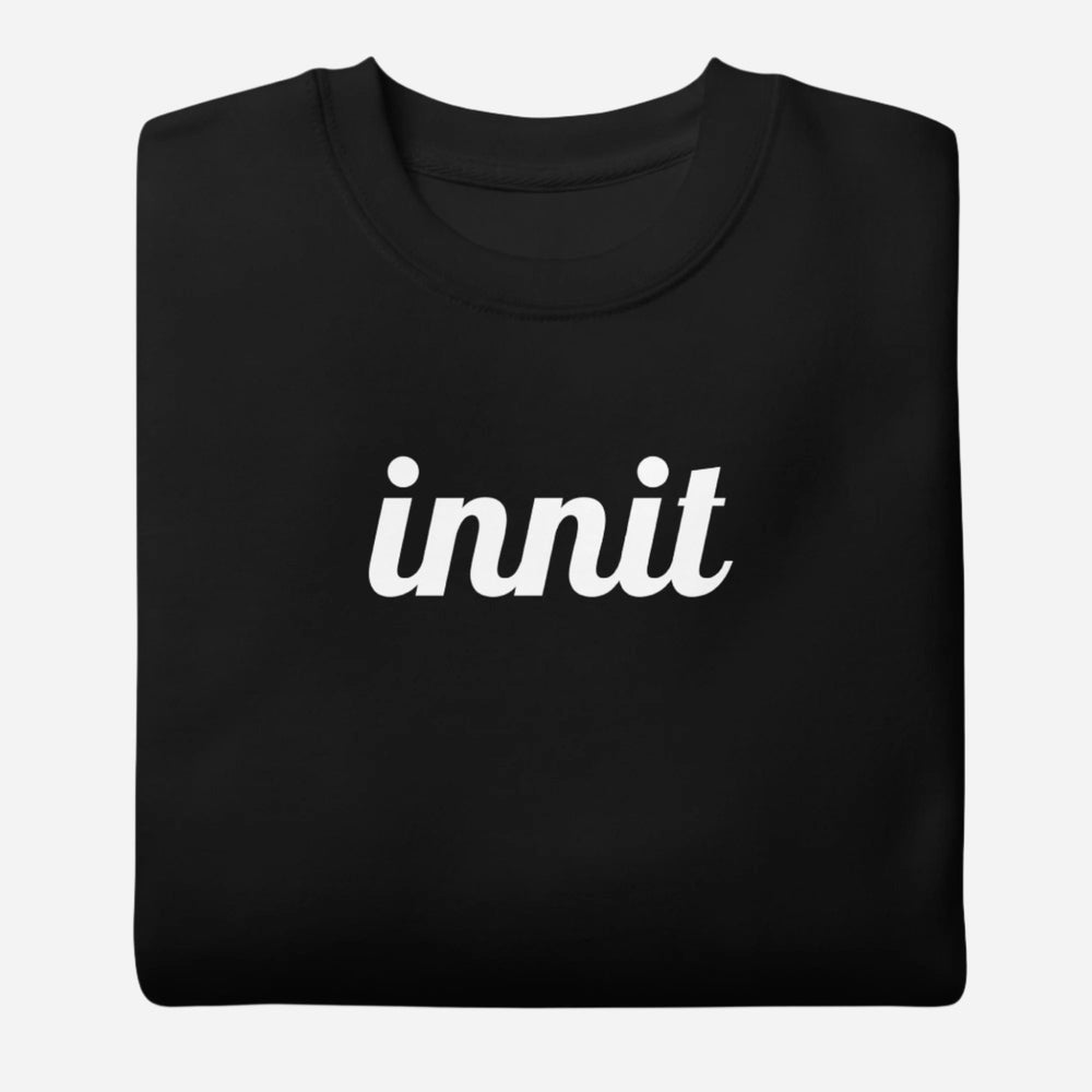 Black sweatshirt, folded view, with white italic 'innit' lettering.