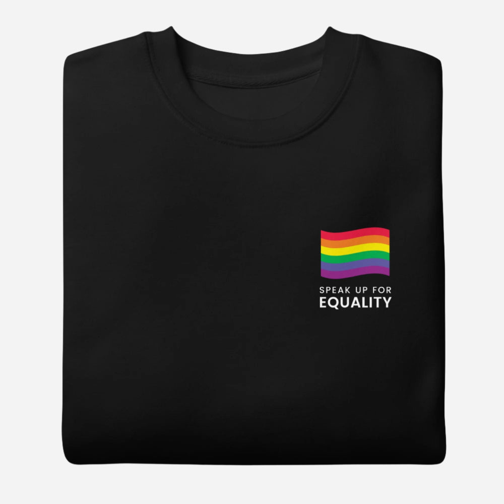 Folded Black sweatshirt, showing a rainbow flag and white "Speak Up for Equality" chest lettering.